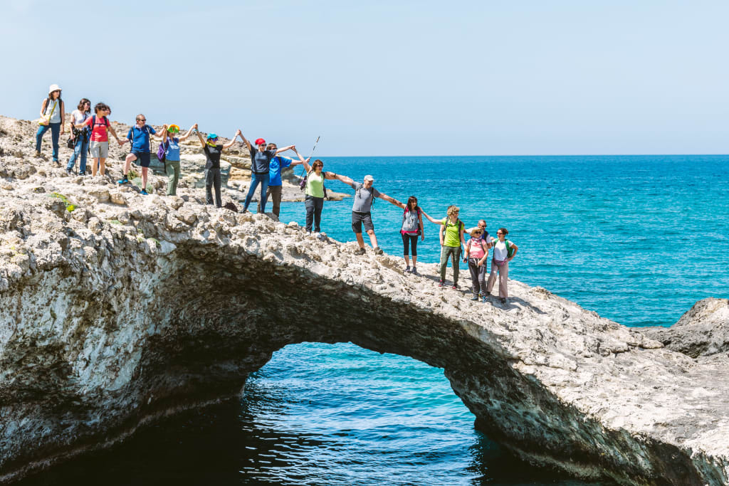 Gruppo durante un trekking su un ponte di pietra sopra una gola, itinerario escursionistico in Grecia con Girolibero nelle Cicladi Minori